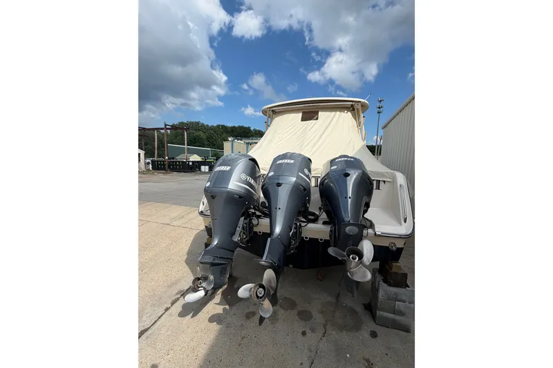 Slide: The Image of 2017 Grady-White Freedom 335 boat with triple Yamaha outboard engines, docked outdoors. - 9