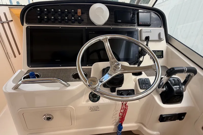 Slide: The Image of 2017 Grady-White Freedom 335 helm with steering wheel and navigation controls. - 20