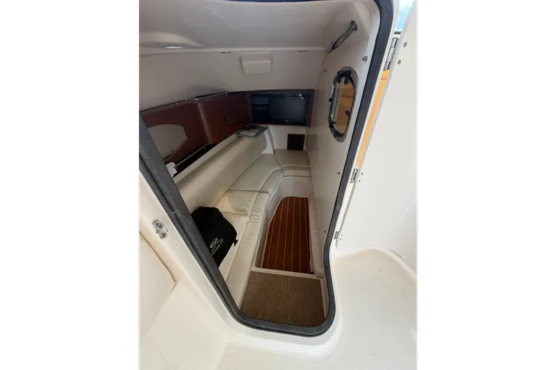 Slide: The Image of 2017 Grady-White Freedom 335 cabin interior with seating and porthole window. - 14