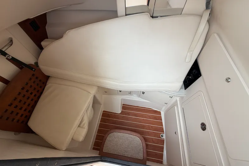 Slide: The Image of Interior cabin of 2017 Grady-White Freedom 335 boat with white seating and wood flooring. - 6