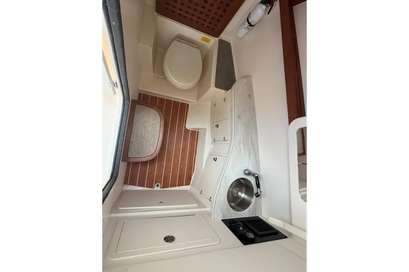 Slide: The Image of 2017 Grady-White Freedom 335 boat interior with toilet, sink, and wooden flooring. - 16