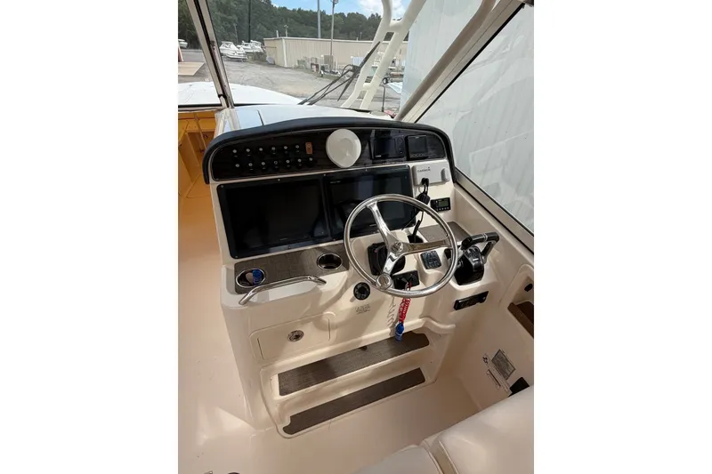 Slide: The Image of 2017 Grady-White Freedom 335 boat helm with steering wheel and navigation controls. - 19