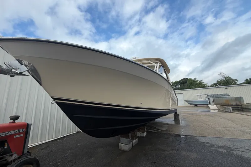Slide: The Image of 2017 Grady-White Freedom 335 boat on dry dock, overcast sky background. - 2