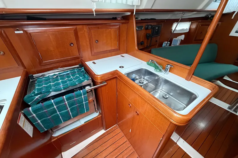 Slide: The Image of Interior of 2001 Beneteau 331 sailboat kitchen with wooden cabinetry and dual sink. - 20