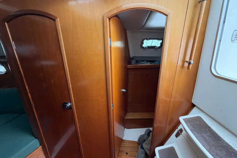 Slide: The Image of Interior of a 2001 Beneteau 331 sailboat, featuring wooden doors and compact cabin space. - 26