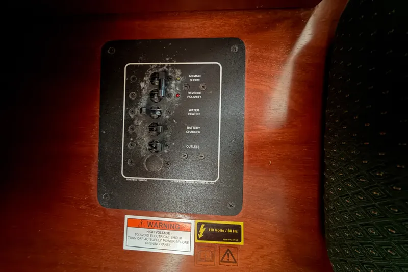 Slide: The Image of Electrical panel on a 2001 Beneteau 331 sailboat, featuring various switches and warning labels. - 19