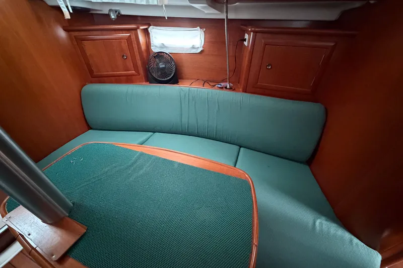 Slide: The Image of Interior of 2001 Beneteau 331 sailboat with green seating and wooden cabinetry. - 10