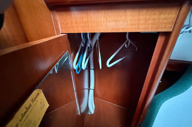Slide: The Image of Wooden closet interior with hangers on a 2001 Beneteau 331 sailboat. - 16