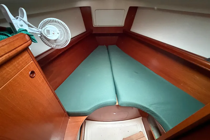 Slide: The Image of Interior cabin of a 2001 Beneteau 331 sailboat with green cushions and wooden finish. - 9
