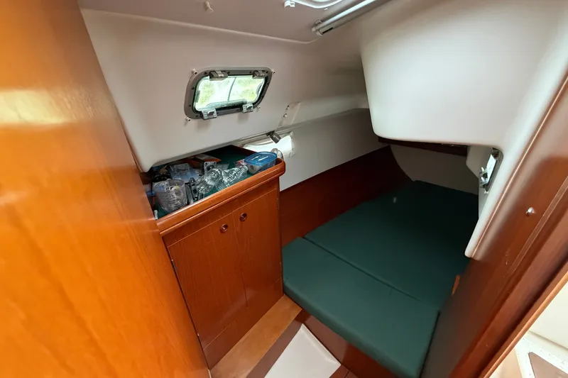 Slide: The Image of Interior cabin of 2001 Beneteau 331 sailboat with storage and green cushions. - 27