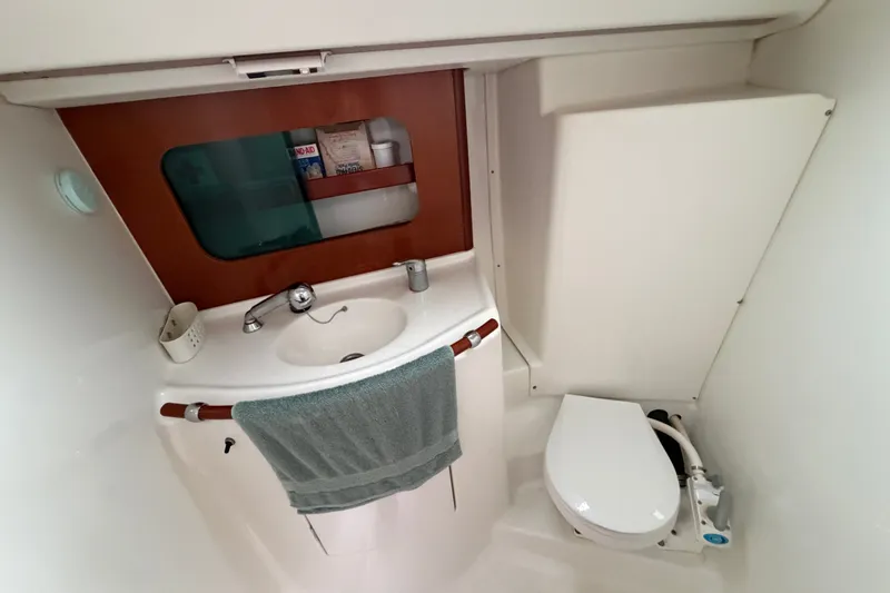Slide: The Image of Compact bathroom in a 2001 Beneteau 331 sailboat, featuring a sink and marine toilet. - 31