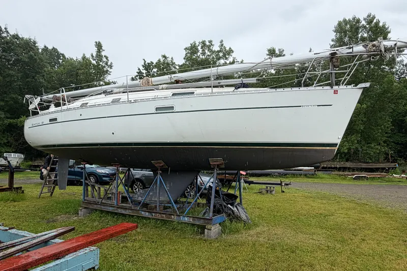 Slide: The Image of 2001 Beneteau 331 sailboat on stands, surrounded by greenery and parked vehicles. - 2