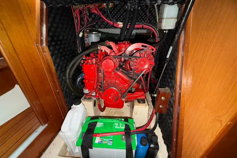 Slide: The Image of Engine compartment of a 2001 Beneteau 331 sailboat, featuring a red engine and battery. - 32