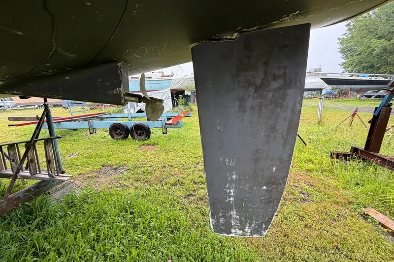 Slide: The Image of 2001 Beneteau 331 sailboat keel and propeller on grassy boatyard. - 6