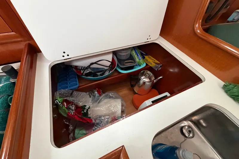 Slide: The Image of Storage compartment in a 2001 Beneteau 331 sailboat galley with kitchen essentials. - 21