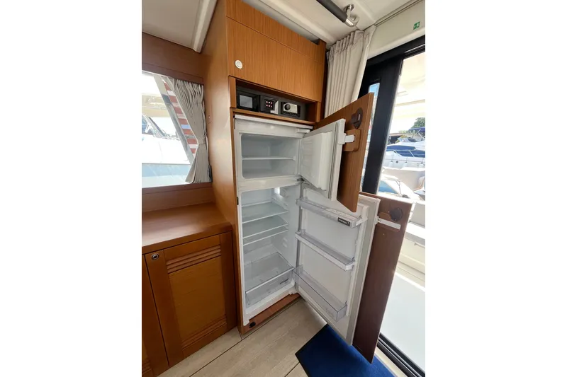 Slide: The Image of Open refrigerator inside 2026 Beneteau Swift Trawler 41 Fly yacht, showcasing interior storage space. - 17