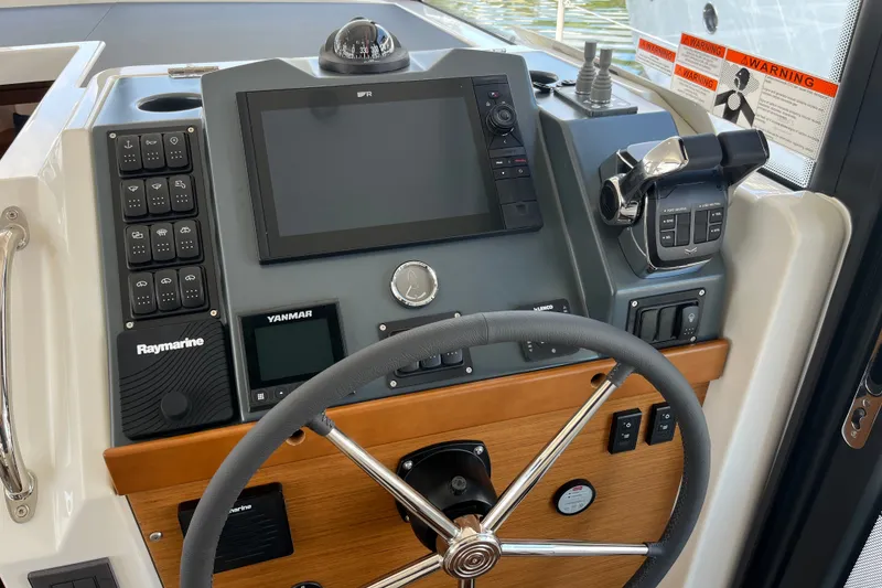 Slide: The Image of Helm of 2026 Beneteau Swift Trawler 41 Fly with advanced navigation controls and steering wheel. - 21