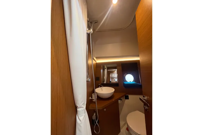 Slide: The Image of Bathroom interior of 2026 Beneteau Swift Trawler 41 Fly, featuring modern fixtures and porthole window. - 26