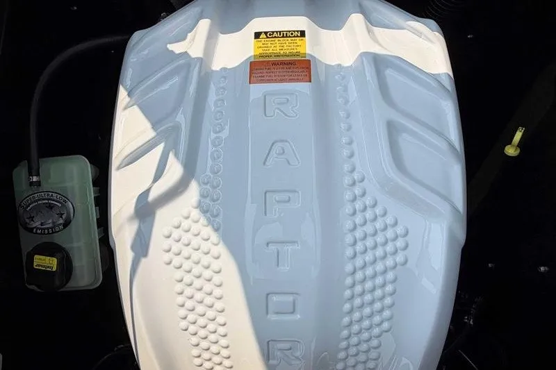 Slide: The Image of Engine cover of a 2027 Tigé Z3 boat featuring "Raptor" branding and caution labels. - 6