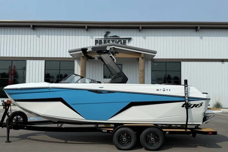 Slide: The Image of 2027 Tigé Z3 boat in blue and white on a trailer outside a Prestige building. - 3
