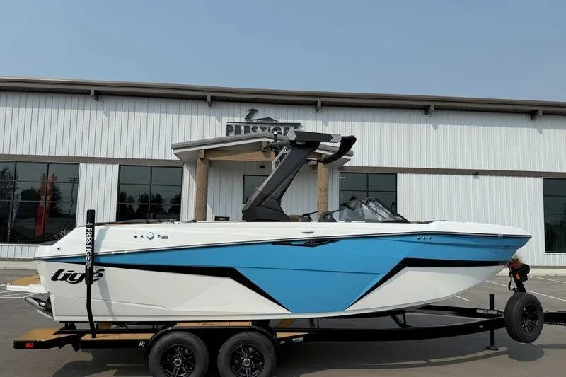 Slide: The Image of 2027 Tigé Z3 boat with blue accents on a trailer outside a dealership. - 11