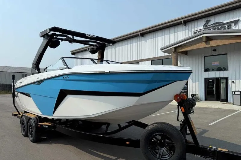 Slide: The Image of 2027 Tigé Z3 boat with blue and white design on a trailer outside a dealership. - 16
