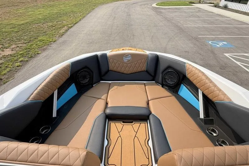 Slide: The Image of 2027 Tigé Z3 boat interior with luxurious tan and black seating, parked on pavement. - 9