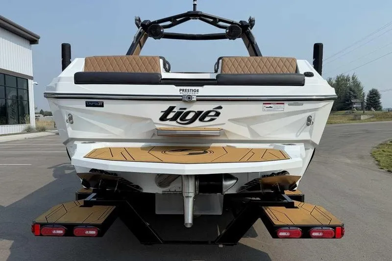 Slide: The Image of 2027 Tigé Z3 boat rear view with tan seating and sleek design. - 2