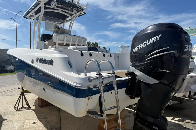Slide: The Image of 2018 Wellcraft 242 Fisherman boat with Mercury 300 Verado engine, docked outdoors. - 2