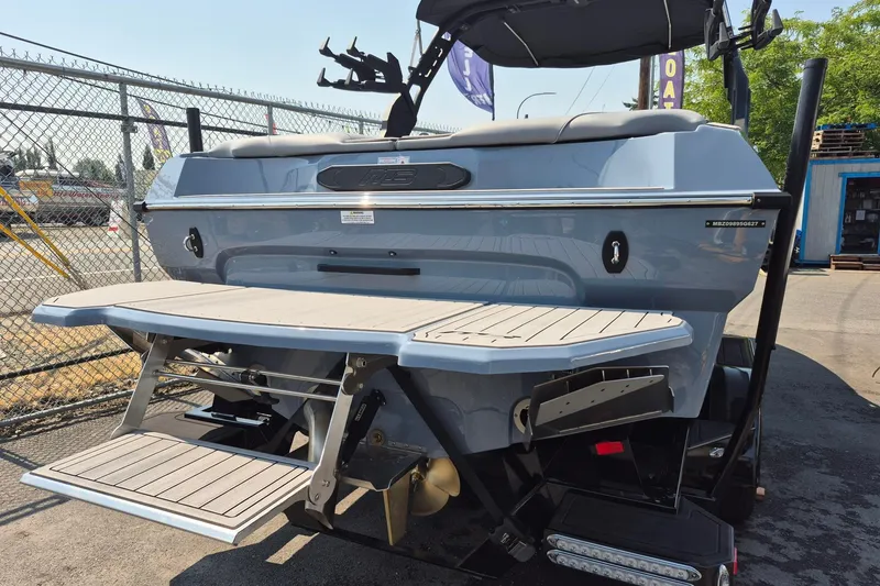 Slide: The Image of 2027 MB B52-23 Classic LIMITED boat, rear view with swim platform, parked outdoors. - 1