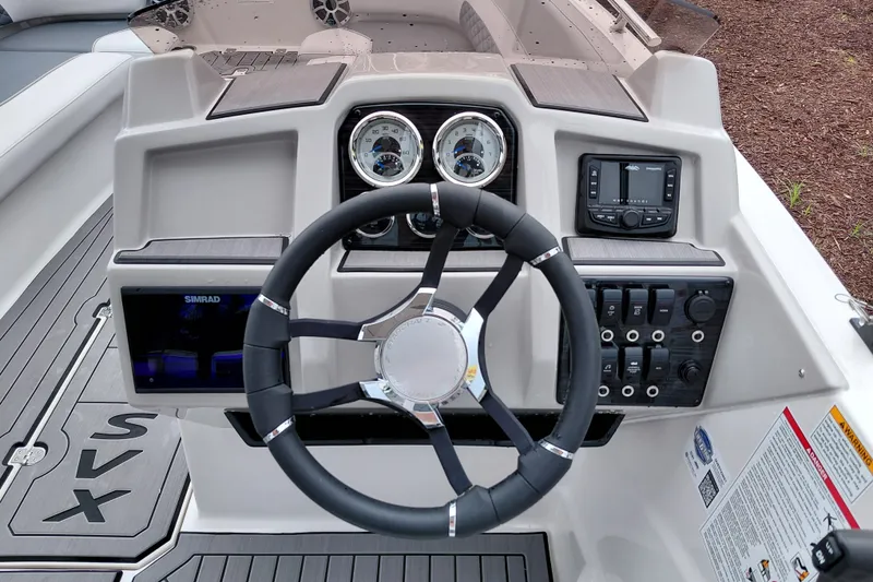 Slide: The Image of Cockpit of 2027 Starcraft SVX 211 OB boat with steering wheel and control panel. - 16