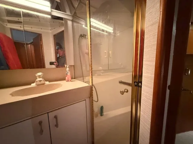 Slide: The Image of Bathroom in a 1997 Ocean Yachts 40ss with a sink, shower, and mirror. - 16