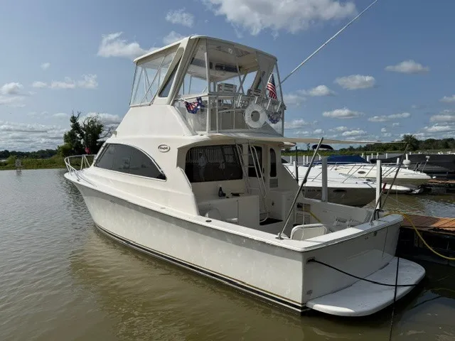 The Image of 1997 Ocean Yachts 40ss on the water, featuring a covered helm and American flag. - 0