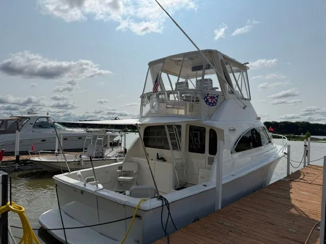Slide: The Image of A 1997 Ocean Yachts 40ss docked on a sunny day. Other boats are visible in the background. - 3