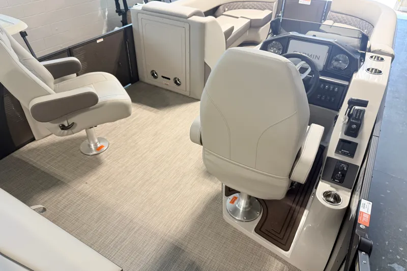Slide: The Image of 2027 Manitou Encore SL 25 boat interior with modern seating and control panel. - 18