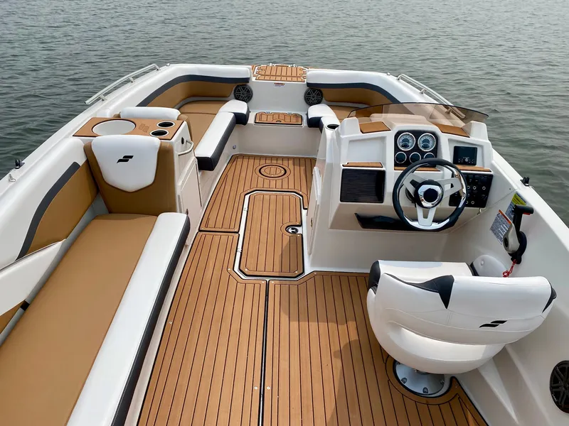 Slide: The Image of The image shows the cockpit of a 2027 Starcraft 211SVXOB boat with sleek seating and wood finish. - 2