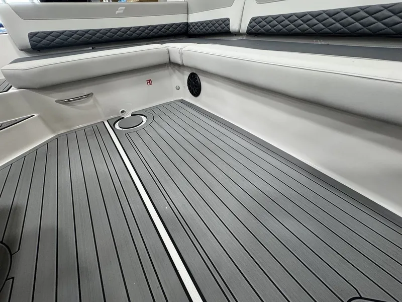 Slide: The Image of The image shows the interior of a 2027 Starcraft 211SVXOB with gray flooring and cushioned seating. - 13