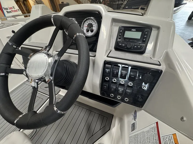 Slide: The Image of Helm of a 2027 Starcraft 211SVXOB with steering wheel, instruments, and switches. - 18