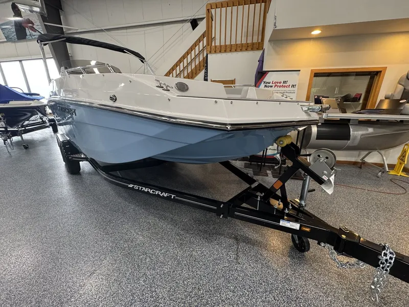 Slide: The Image of The image shows a 2027 Starcraft 211SVXOB boat in a showroom. - 1