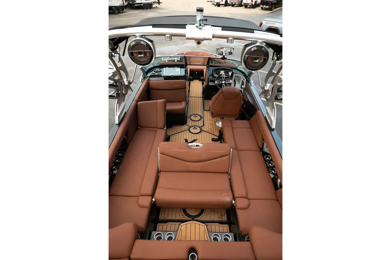 Slide: The Image of 2020 MasterCraft XT25 boat interior with brown seating and modern dashboard. - 31