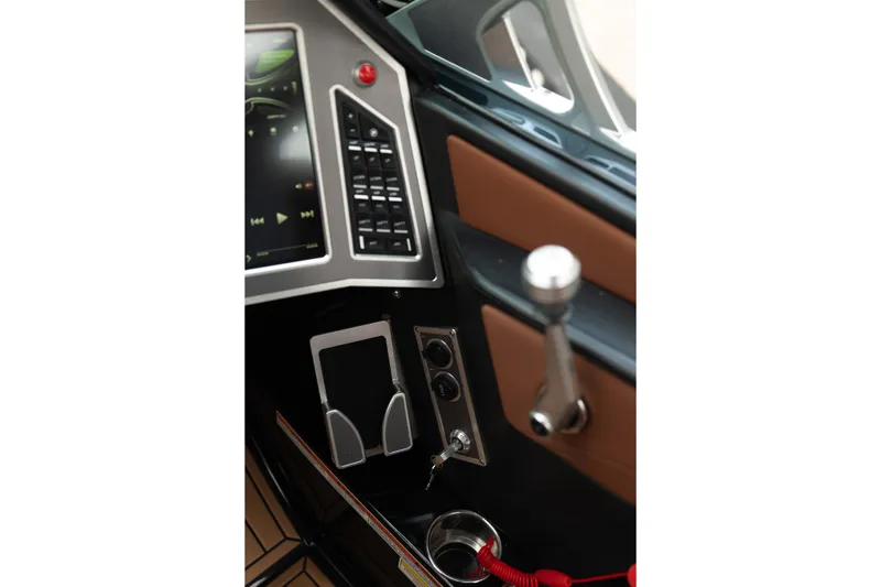 Slide: The Image of 2020 MasterCraft XT25 boat dashboard with control panel and cup holder. - 24