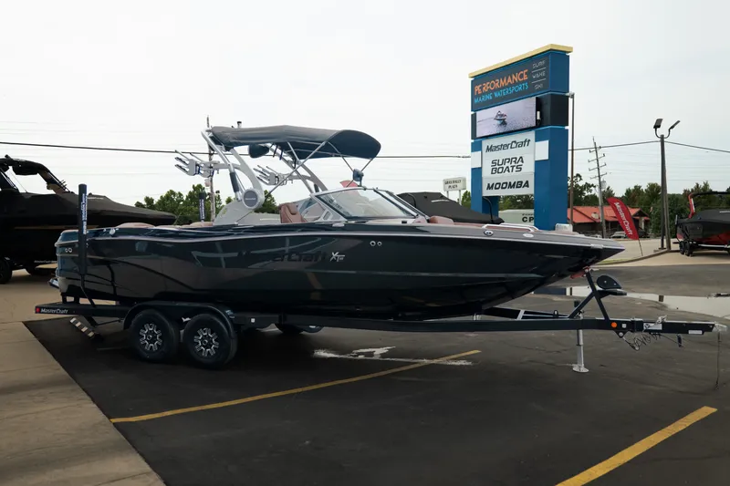 Slide: The Image of 2020 MasterCraft XT25 boat on trailer at dealership, showcasing sleek design and modern features. - 11