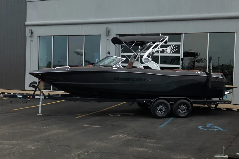 Slide: The Image of 2020 MasterCraft XT25 boat on trailer outside a modern building. - 3