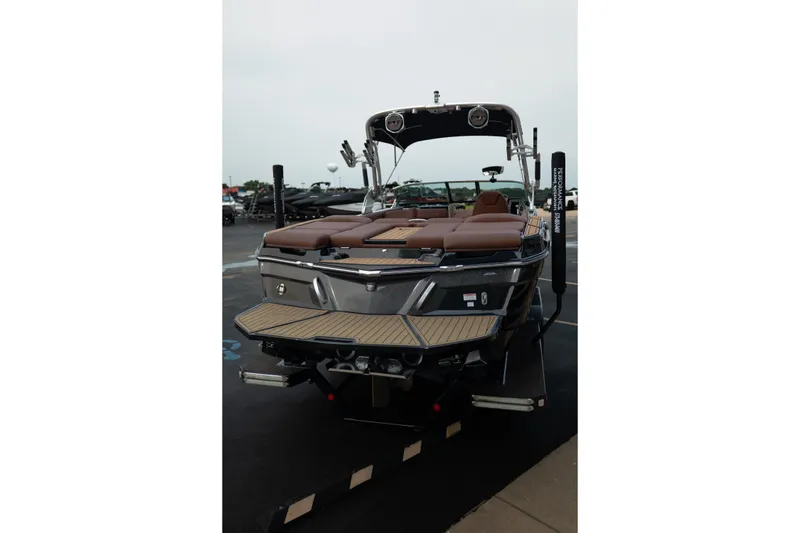 Slide: The Image of 2020 MasterCraft XT25 boat with brown seating, docked on a trailer. - 10