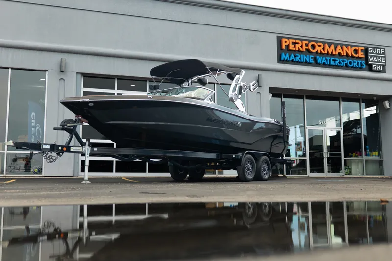 The Image of 2020 MasterCraft XT25 boat on trailer outside Performance Marine Watersports store. - 1