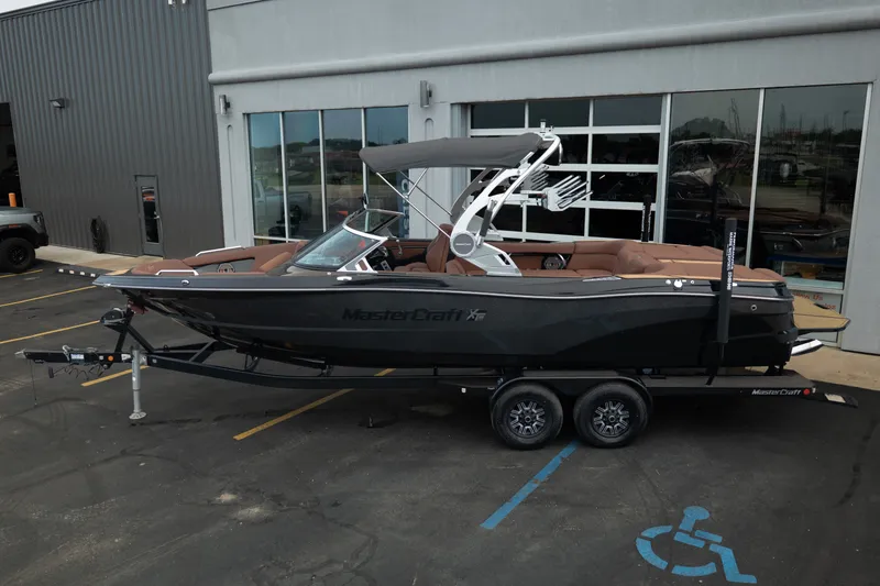 Slide: The Image of 2020 MasterCraft XT25 boat on trailer, parked outside a building. - 5