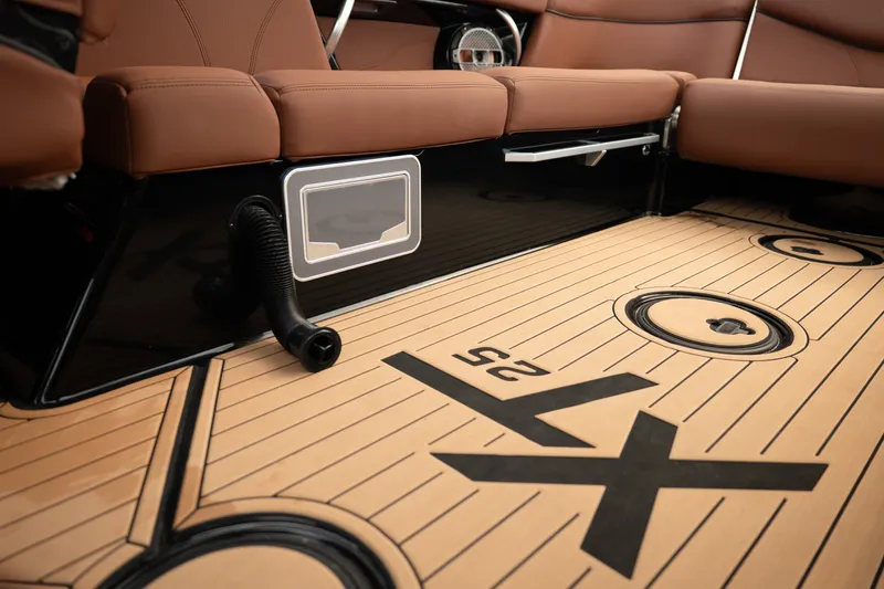 Slide: The Image of 2020 MasterCraft XT25 interior with brown seating and teak-style flooring. - 28