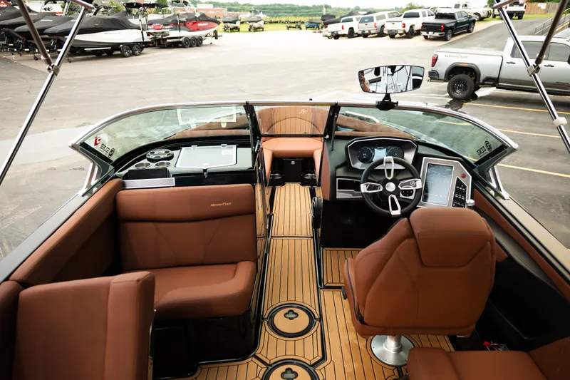 Slide: The Image of 2020 MasterCraft XT25 boat interior with brown seating and modern dashboard. - 36