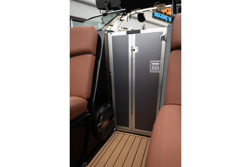 Slide: The Image of 2020 MasterCraft XT25 interior with brown seating and sleek metal door. - 18