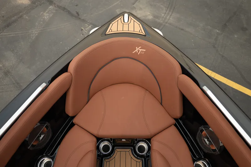 Slide: The Image of 2020 MasterCraft XT25 boat interior with brown leather seating and cup holders. - 16